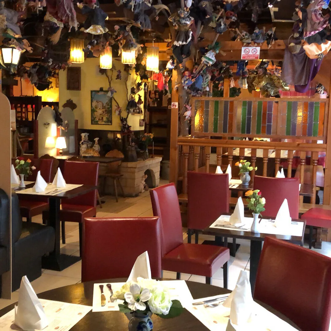 Salle avec marionnettes suspendues, lanternes et vitrail