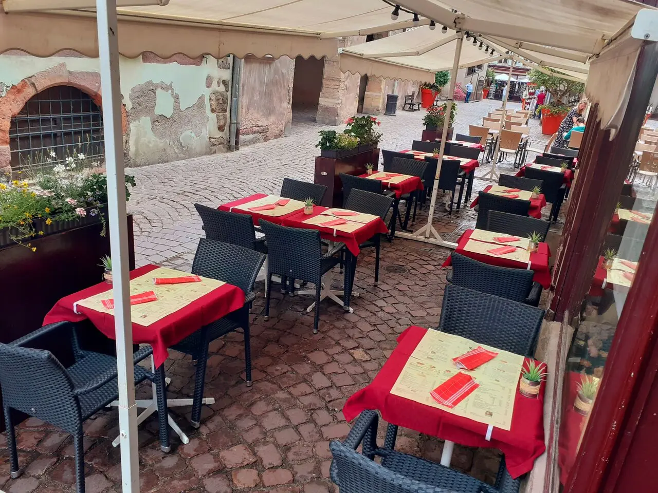 Terrasse aux nappes rouges sur les pavés